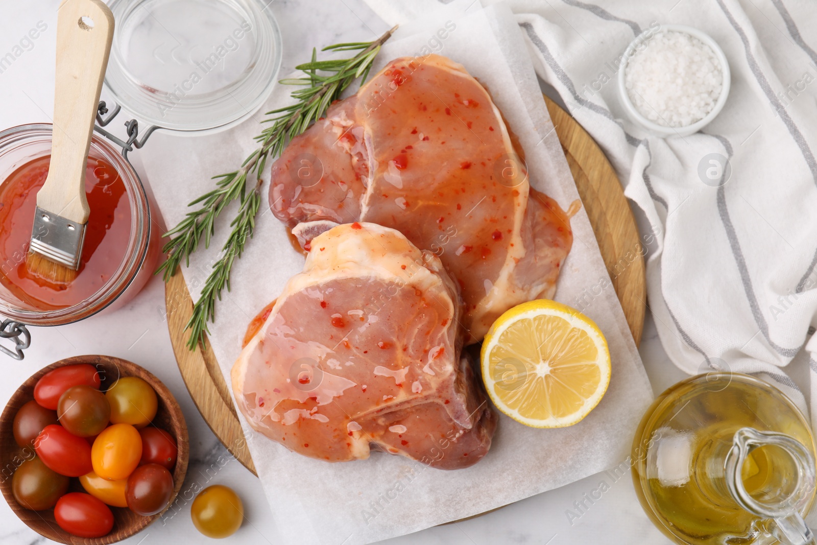 Photo of Flat lay composition with raw marinated meat, lemon and rosemary on white table