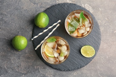 Glasses with delicious mint julep cocktail on slate plate, top view