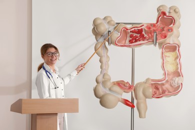 Professor giving lecture in gastroenterology. Projection screen with illustration of large intestine