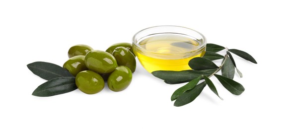 Photo of Cooking oil in glass bowl, olives and leaves on white background