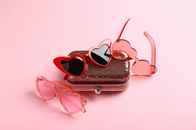 Photo of Stylish heart shaped sunglasses and wallet on color background