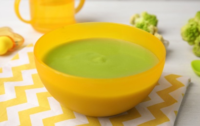 Photo of Bowl of healthy baby food on wooden table