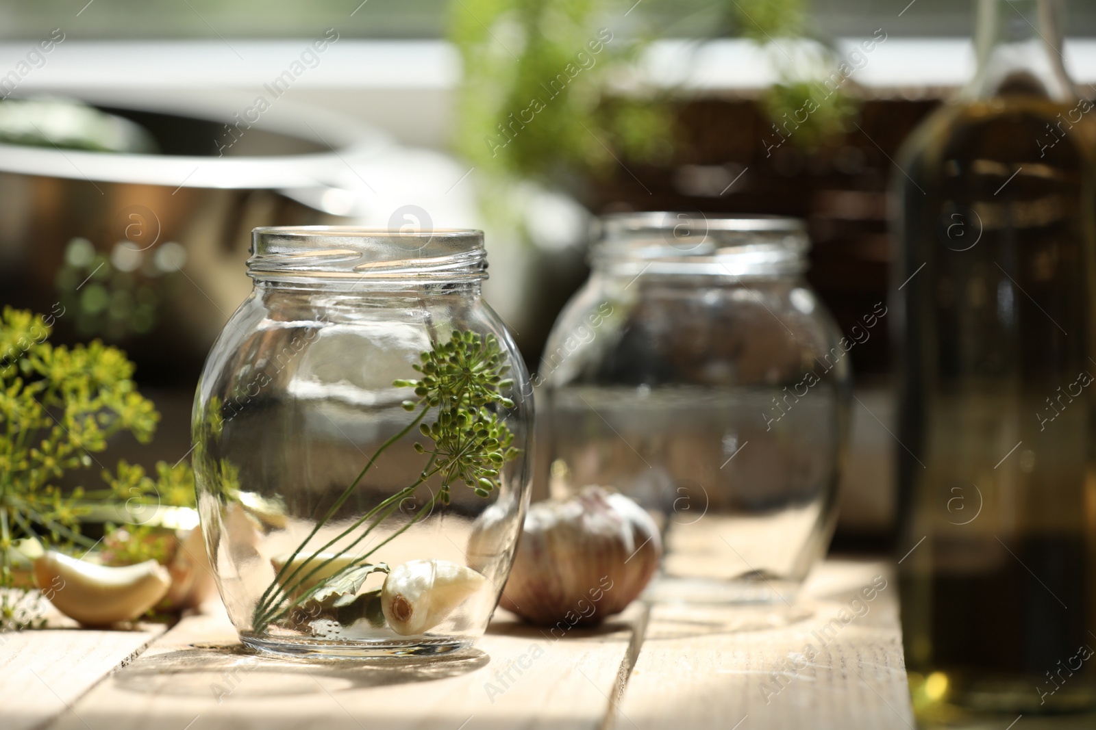 Photo of Empty glass jar and ingredients prepared for canning on wooden table. Space for text