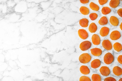 Photo of Flat lay composition with apricots on marble background, space for text. Dried fruit as healthy food