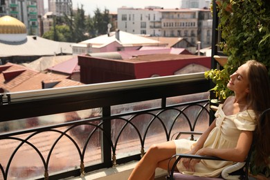 Beautiful young woman on balcony. Space for text