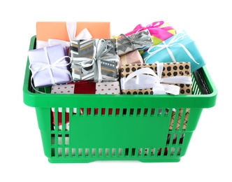 Photo of Green shopping basket with different gifts on white background