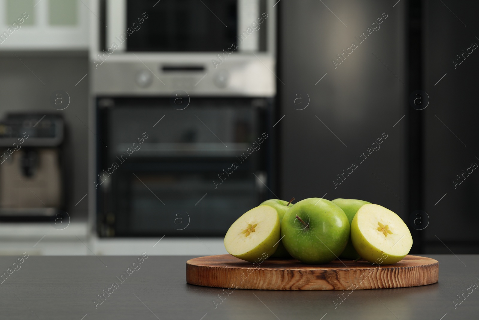 Photo of Fresh apples on grey table in kitchen. Space for text