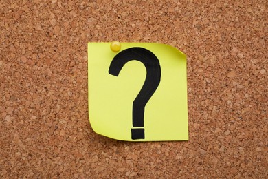 Note paper with question mark pinned to cork board