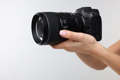 Photographer with camera on light grey background, closeup