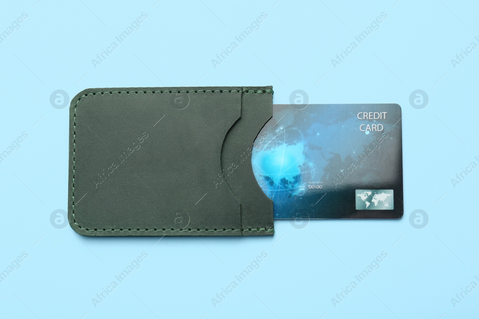 Photo of Leather card holder with credit card on light blue background, top view