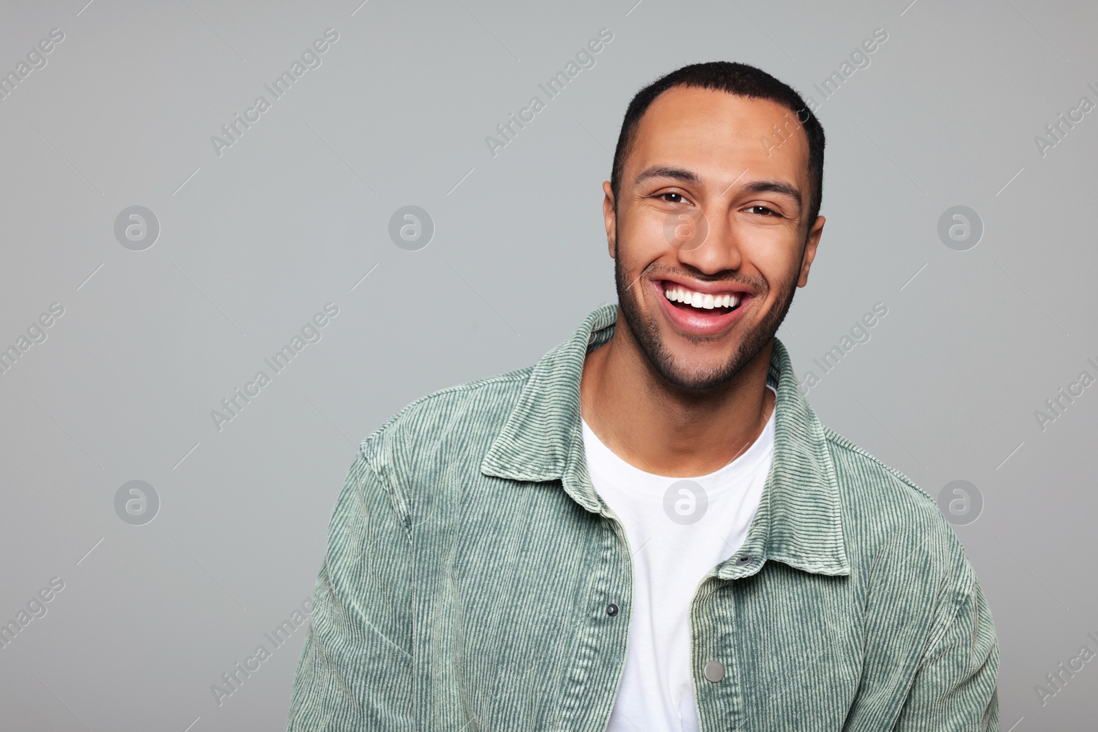 Photo of Portrait of smiling African American man on light grey background. Space for text