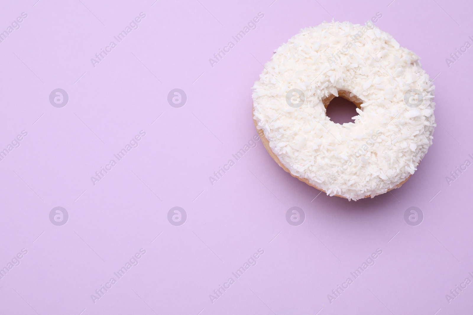 Photo of Tasty donut with coconut shavings on purple background, top view. Space for text
