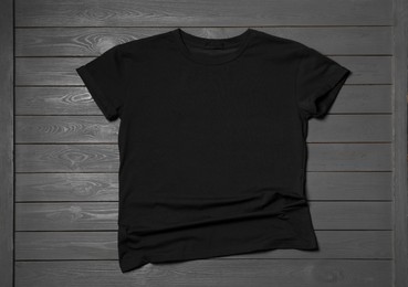 Photo of Stylish black T-shirt on gray wooden table, top view