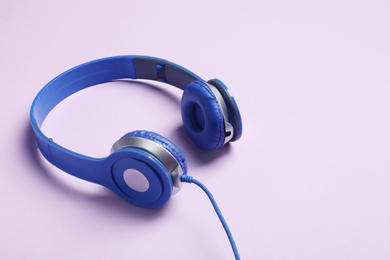 Stylish headphones on color background. Space for text