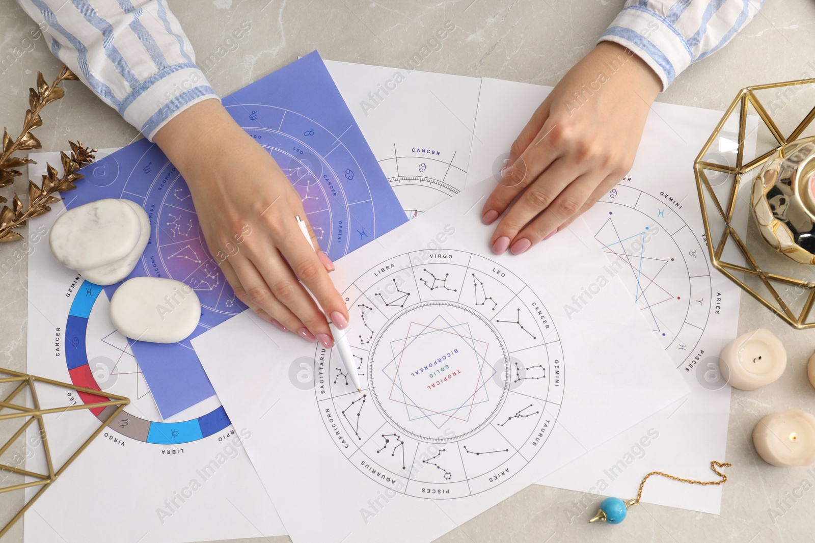 Photo of Astrologer using zodiac wheel for fate forecast at table, top view. Fortune telling