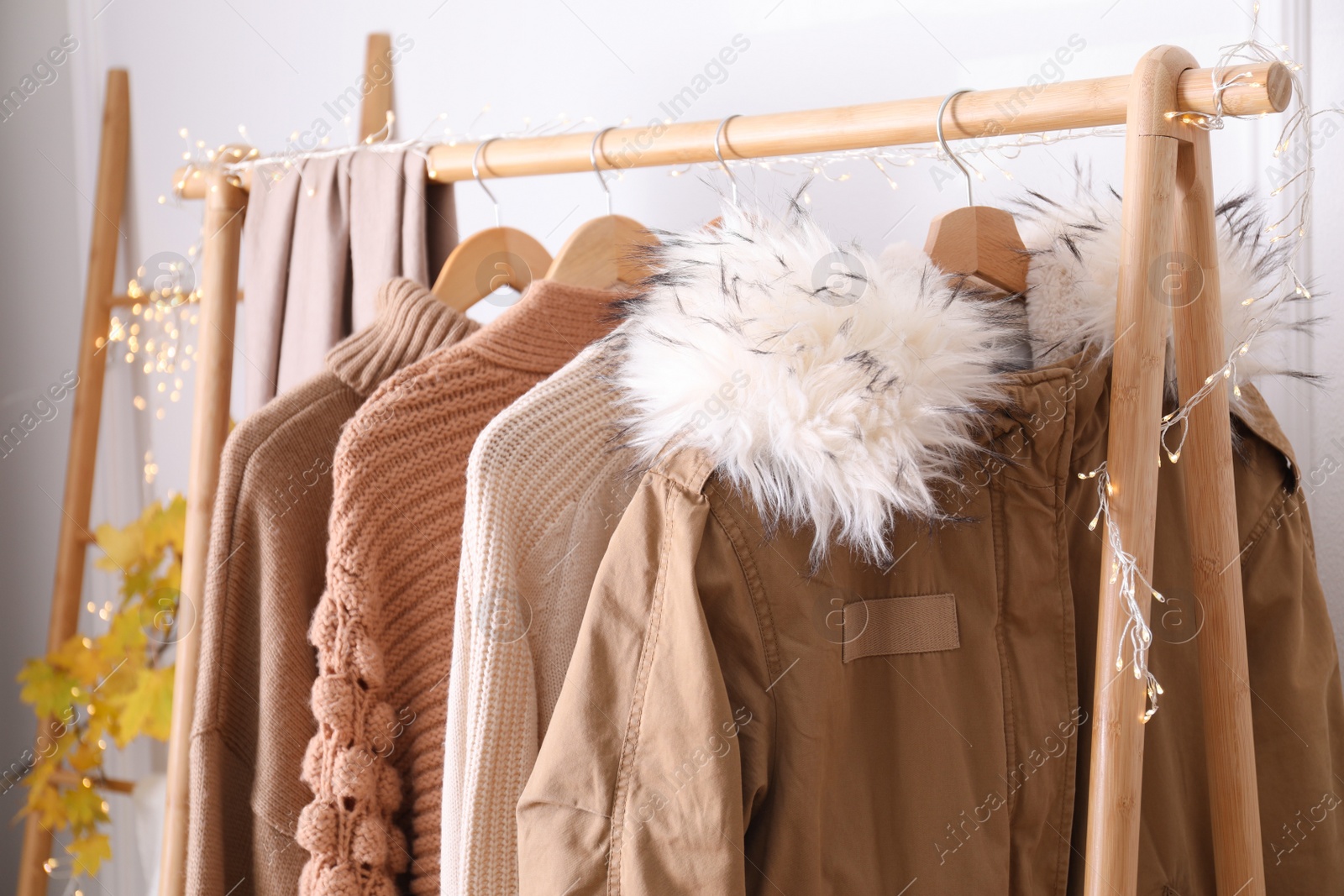 Photo of Rack with stylish warm clothes indoors, closeup