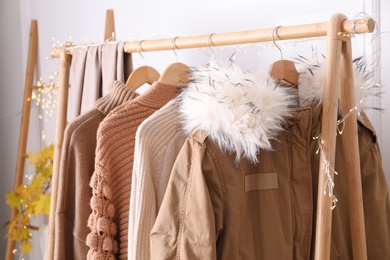 Photo of Rack with stylish warm clothes indoors, closeup