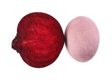 Photo of Colorful Easter egg painted with natural dye and cut beet on white background, top view