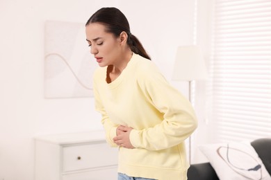 Woman suffering from abdominal pain at home. Unhealthy stomach