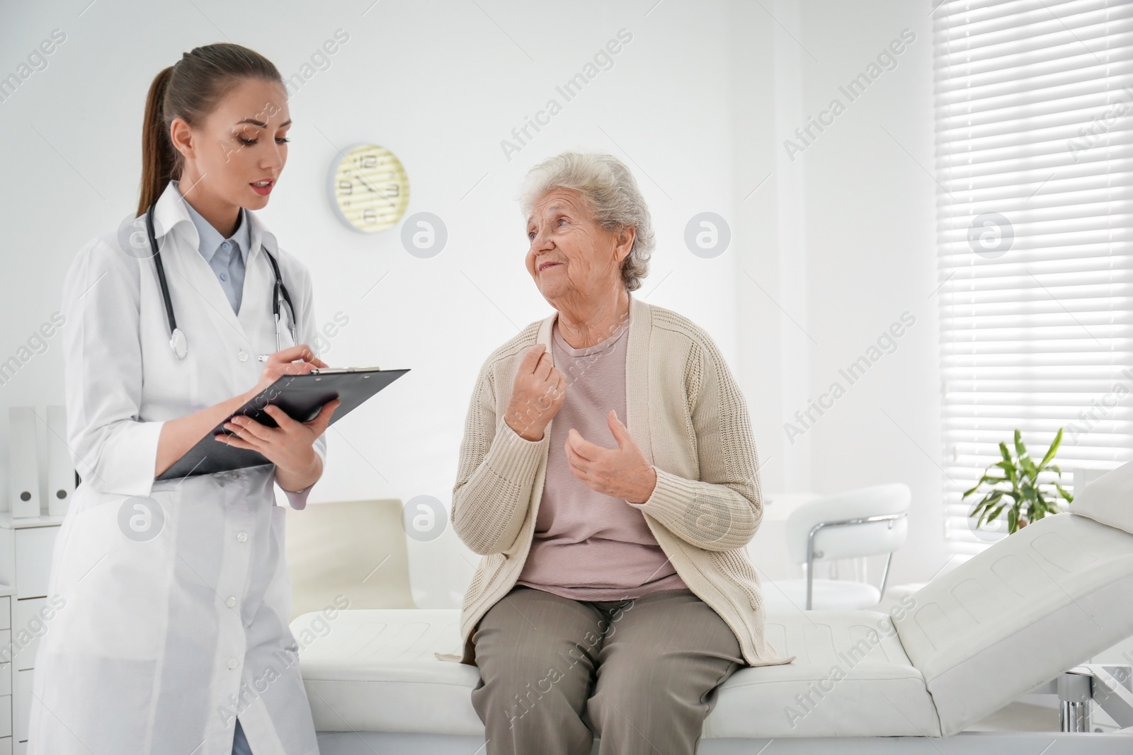 Photo of Doctor examining senior patient in modern office