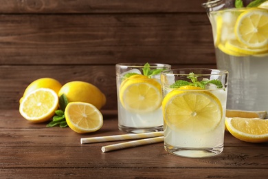 Photo of Glassware with natural lemonade on wooden table