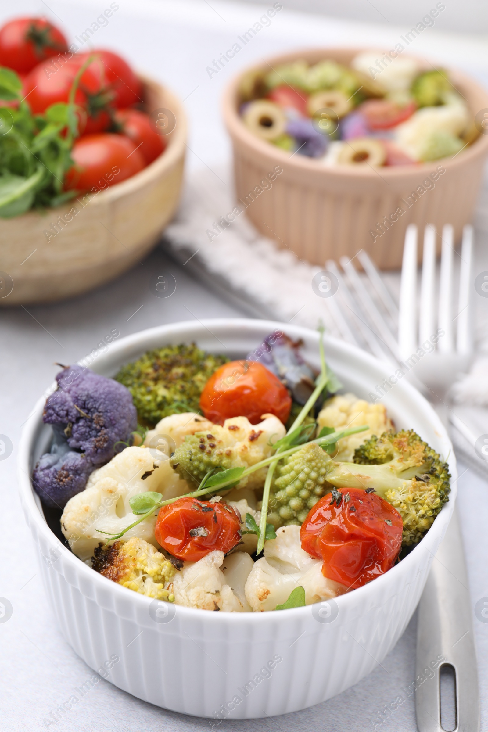 Photo of Delicious salad with cauliflower and tomato served on white table