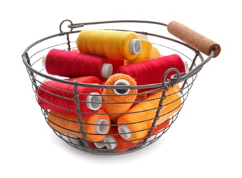 Photo of Basket with set of color sewing threads on white background