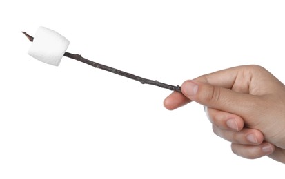 Photo of Woman holding twig with delicious puffy marshmallow on white background, closeup