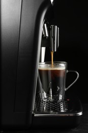 Photo of Making coffee with modern espresso machine on grey table against black background