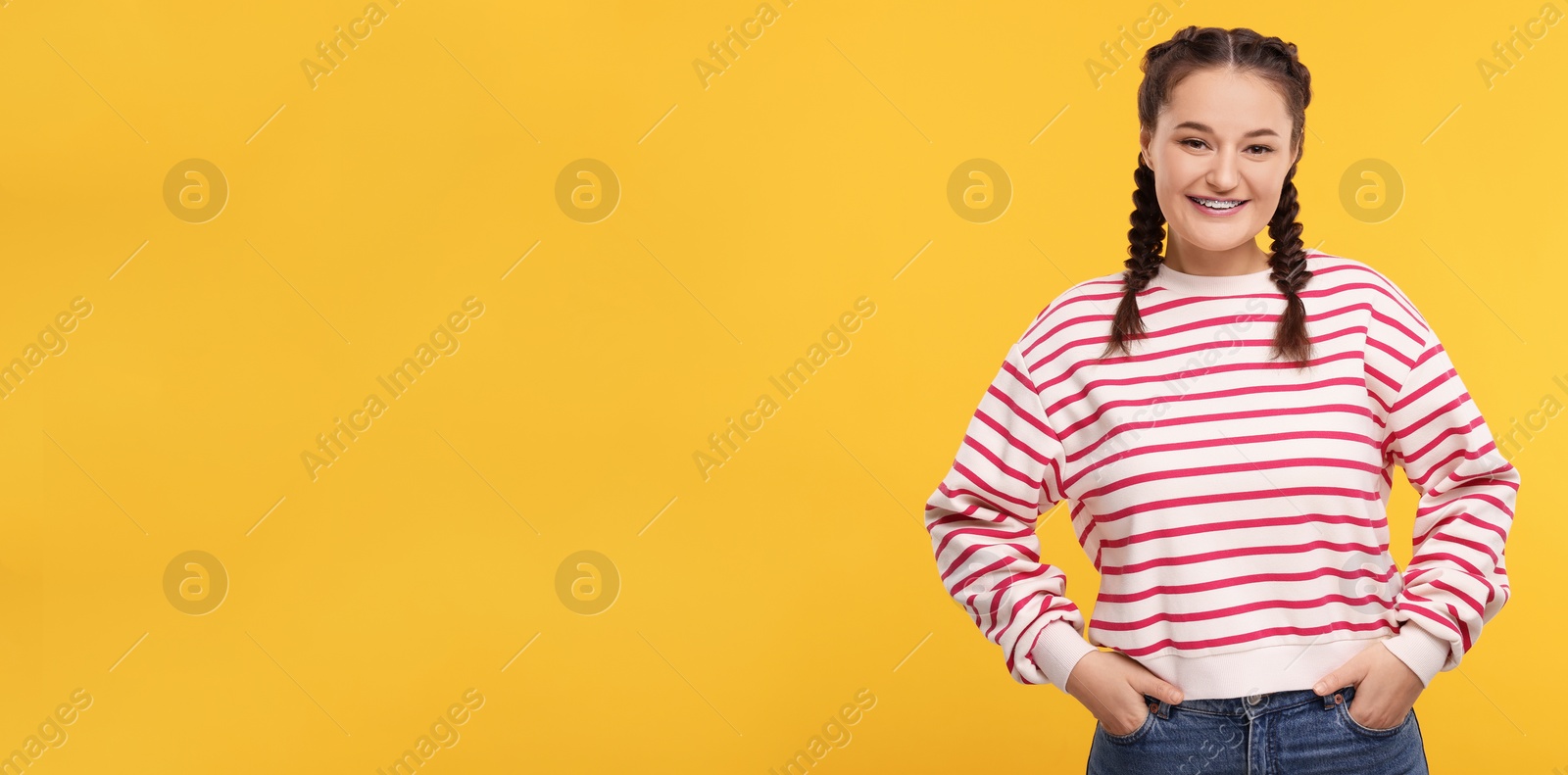 Image of Smiling woman with braces on orange background. Banner design with space for text