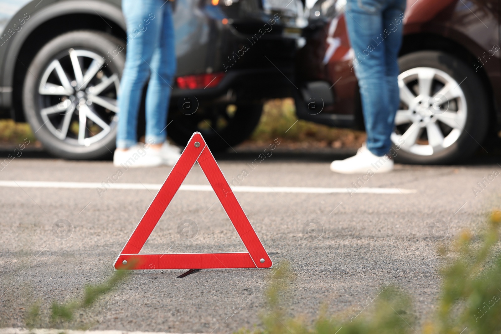 Photo of Emergency stop sign near people discussing car accident on road. Auto insurance