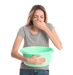 Photo of Woman with basin suffering from nausea on white background. Food poisoning