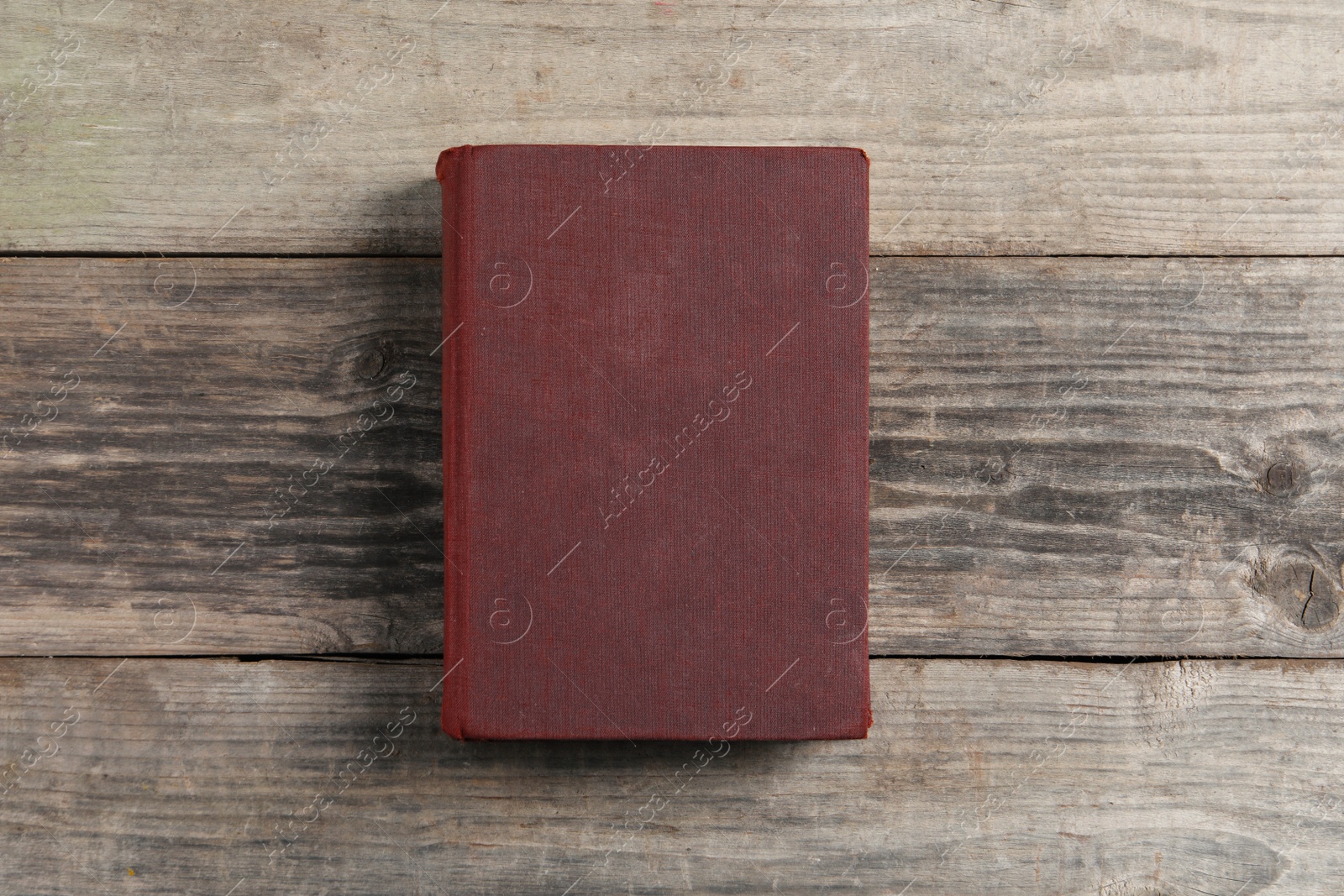 Photo of Old hardcover book on grey wooden table, top view