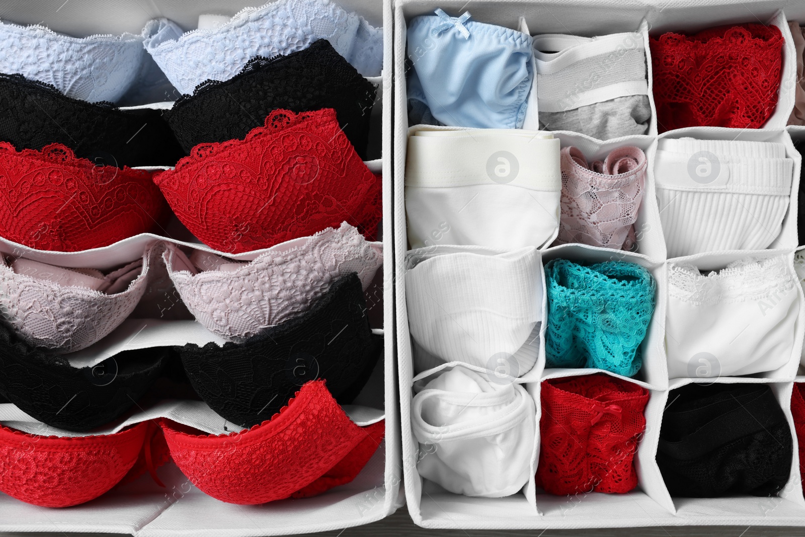 Photo of Organizers with folded women's underwear on table, flat lay