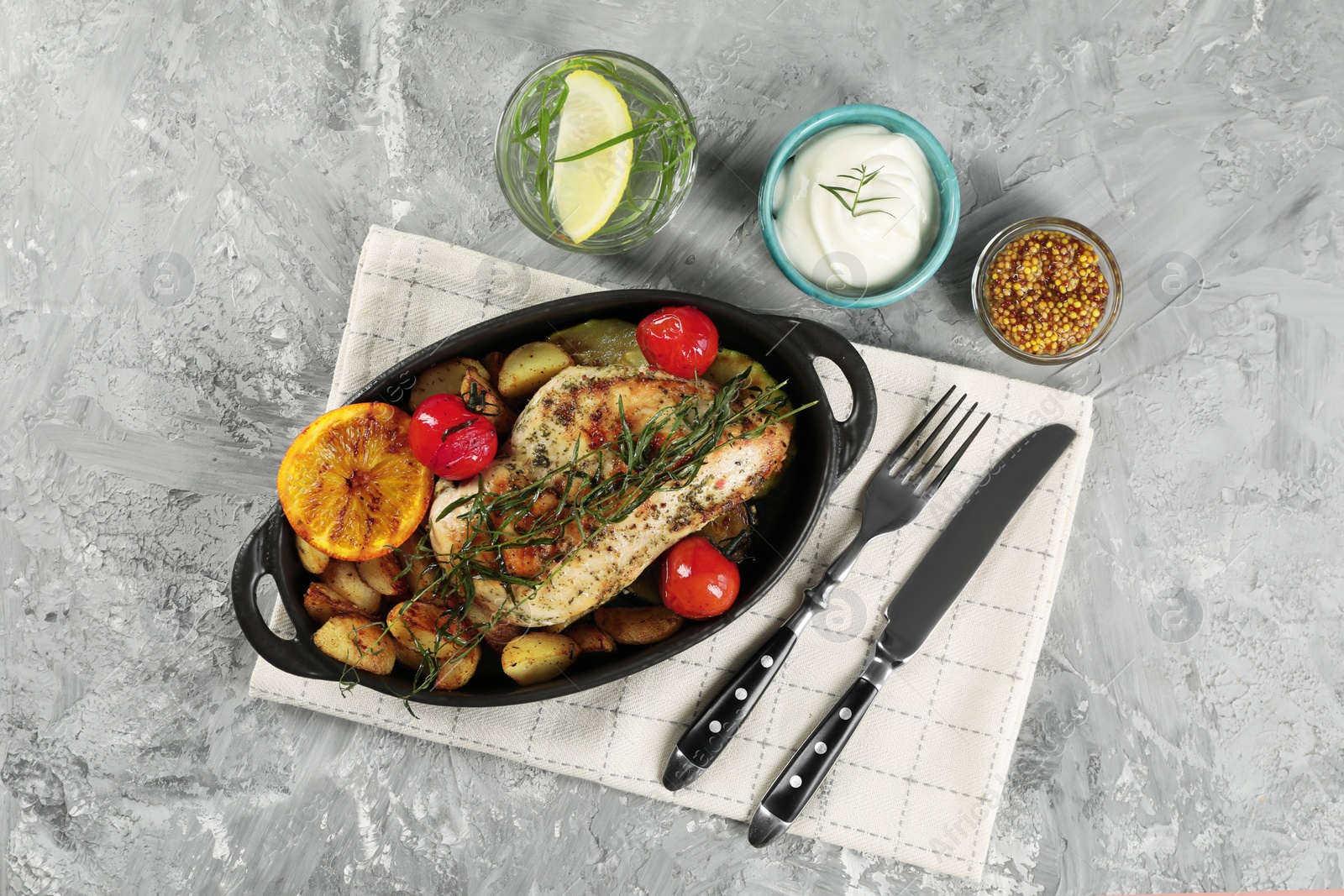 Photo of Tasty chicken, vegetables, drink with tarragon and salad dressings served on grey table, flat lay