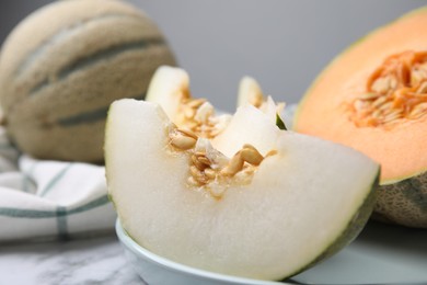Photo of Tasty colorful ripe melons on white marble table, closeup