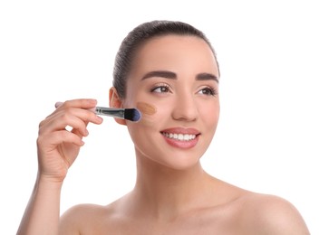 Photo of Woman applying foundation on face with brush against white background