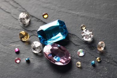 Photo of Different beautiful precious gemstones for jewelry on grey background