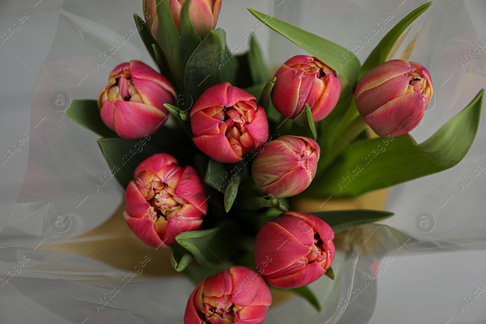 Photo of Beautiful bouquet of tulips on blurred background, top view