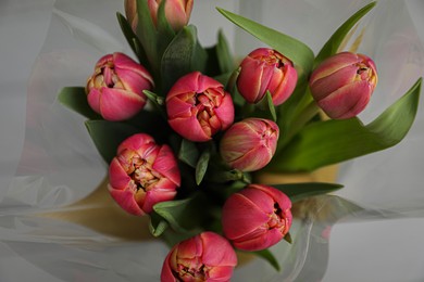 Photo of Beautiful bouquet of tulips on blurred background, top view