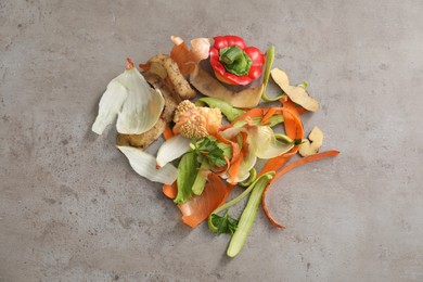 Photo of Peels of fresh vegetables on grey textured table, flat lay