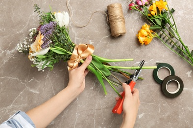 Female florist pruning stem at table, top view