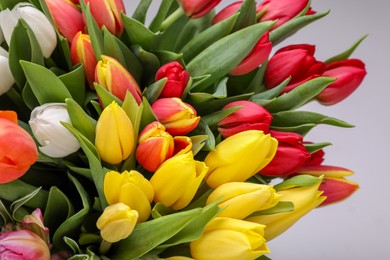 Photo of Beautiful colorful tulip flowers on light grey background, closeup with above view