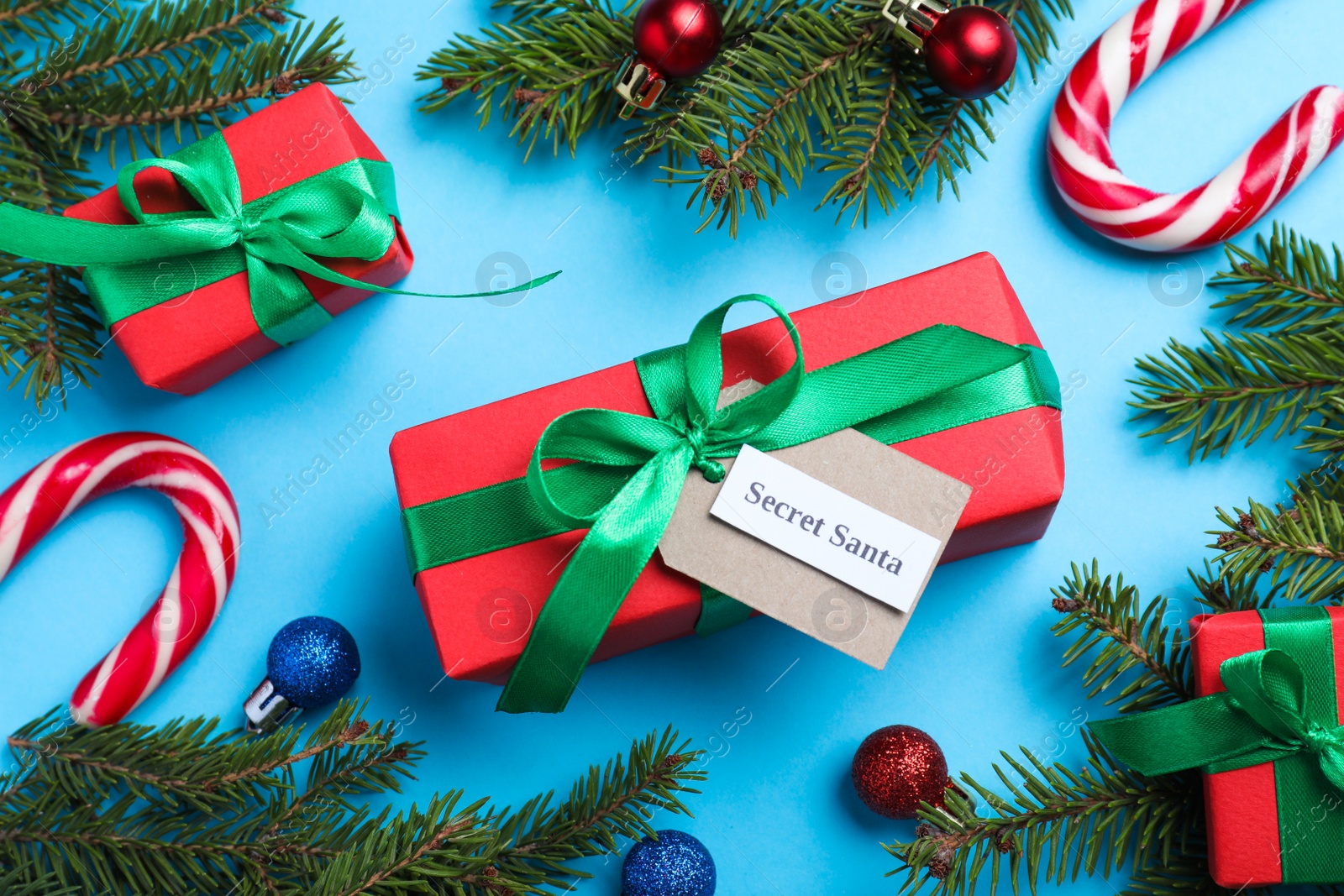 Photo of Flat lay composition with presents from secret Santa on light blue background