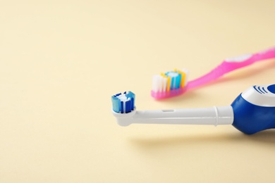 Manual and electric toothbrushes on color background. Dental care