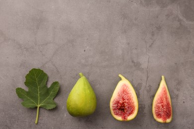 Photo of Cut and whole green figs with leaf on light gray table, flat lay. Space for text