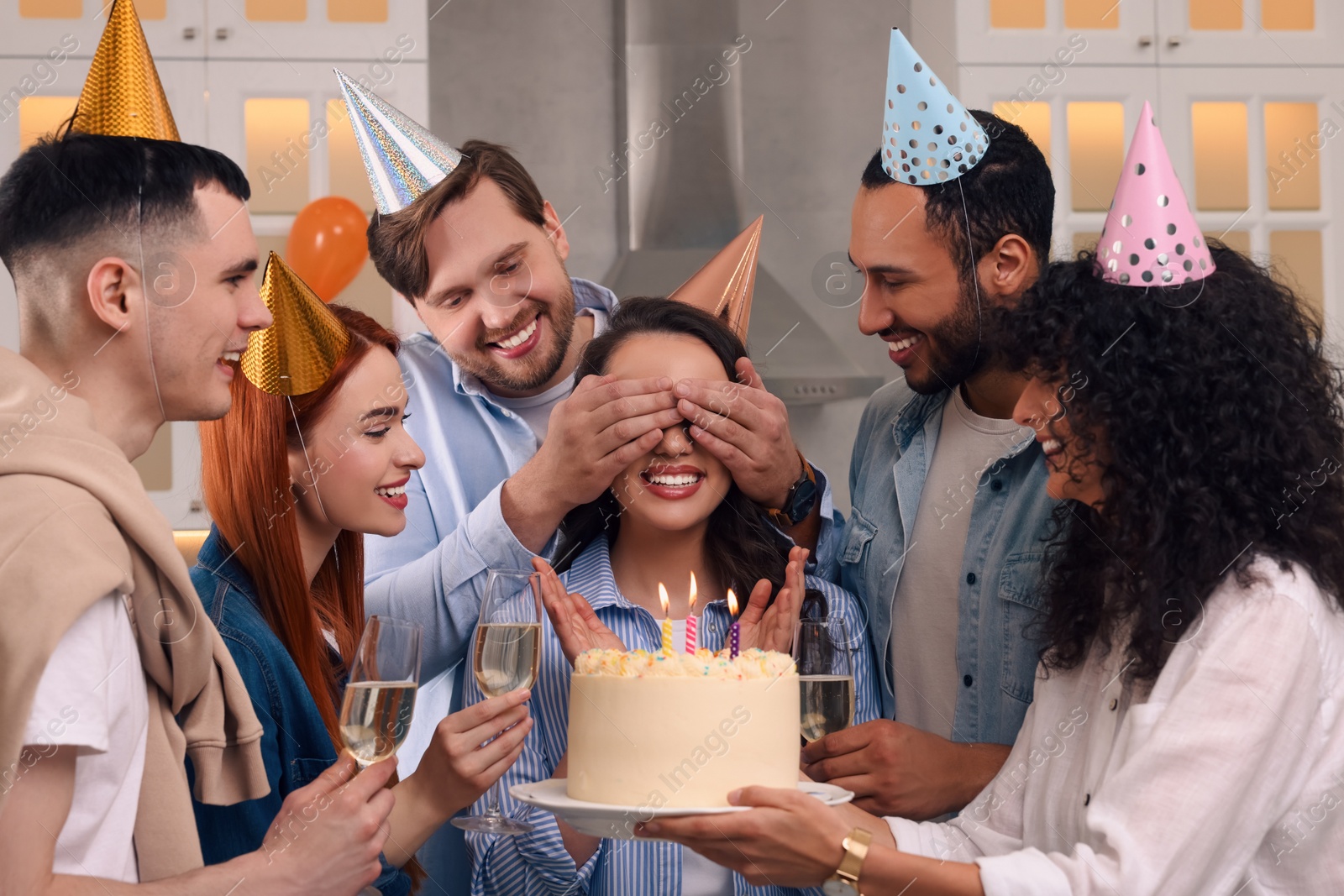 Photo of Happy friends with tasty cake celebrating birthday indoors