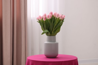 Photo of Beautiful bouquet of fresh pink tulips on table indoors