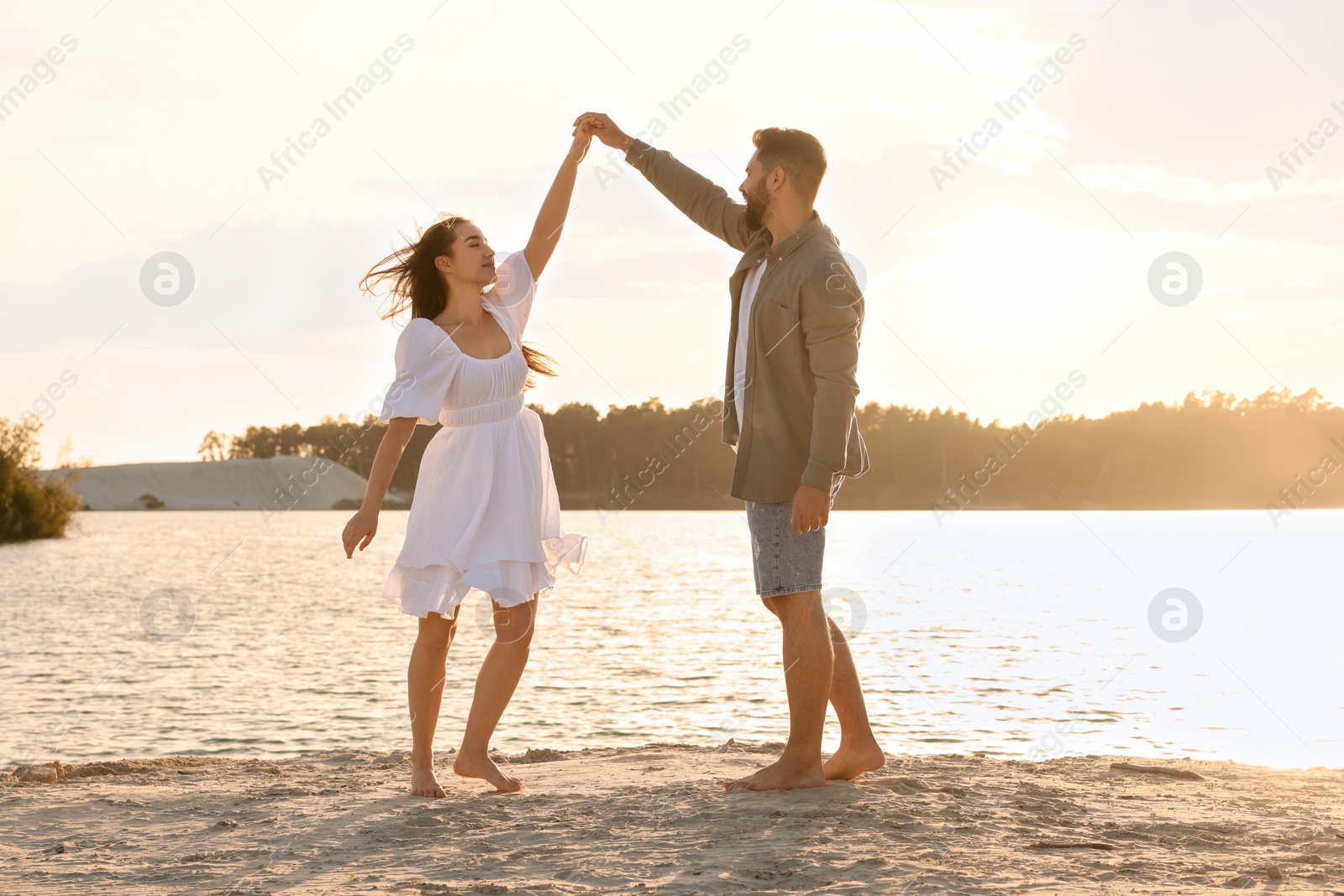 Photo of Happy couple dancing near river on sunny day