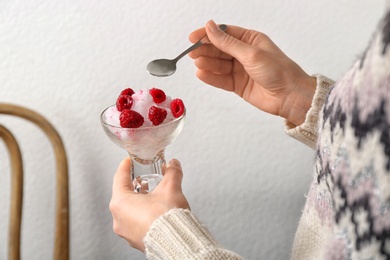 Photo of Woman eating tasty snow ice cream dessert on light background, closeup